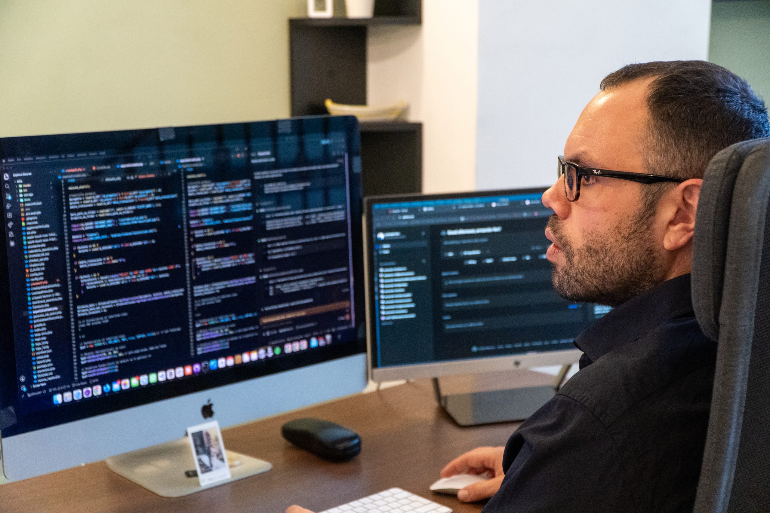 Armando Ferrandino davanti a due monitor con il codice di un sito web